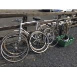 Two bicycles, a quantity of bike wheels & tyres, and a box of bicycle accessories - pedals, seats,