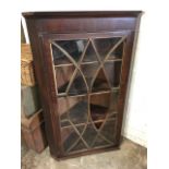 A nineteenth century mahogany corner cabinet with astragel glazed crossbanded door enclosing