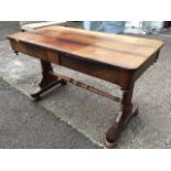 A George IV rosewood writing table, the rectangular rounded top having twin frieze drawers raised on