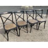 A set of four ebonised bentwood dining chairs, having bar backs above crossed slats and rounded