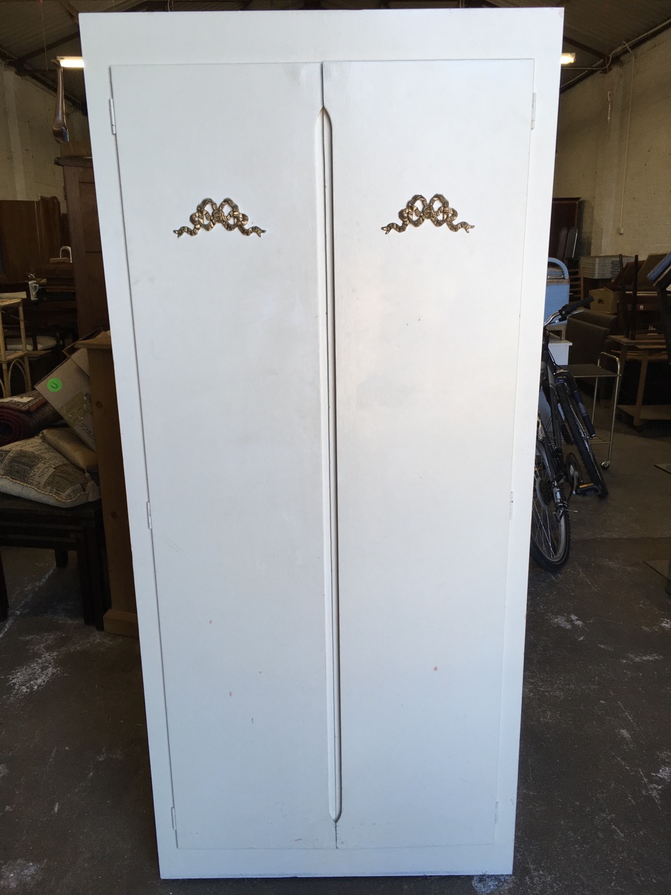 A painted cupboard, the doors with applied gilt ribbon bow decoration enclosing shelves. - Image 5 of 6