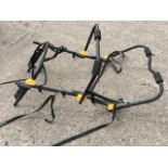 A Halfords vehicle bicycle rack, the tubular bars mounted with straps and foam pads, to take three