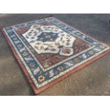 An oriental style rug, the ivory field woven with central blue star medallion and pink spandrels