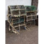 Six lobster pots, the arched cages covered in netting with grill bases, each with two apertures. (