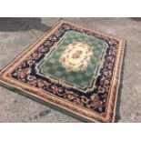 An oriental style rug woven with oval fawn floral medallion in green field having lattice