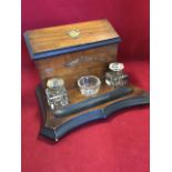 A Victorian walnut desktidy, the stationary rack with angled lid having brass mounts, the inkstand