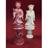 Two Victorian Chinese carved and stained ivory chess pieces, the cloaked figures on pierced balls