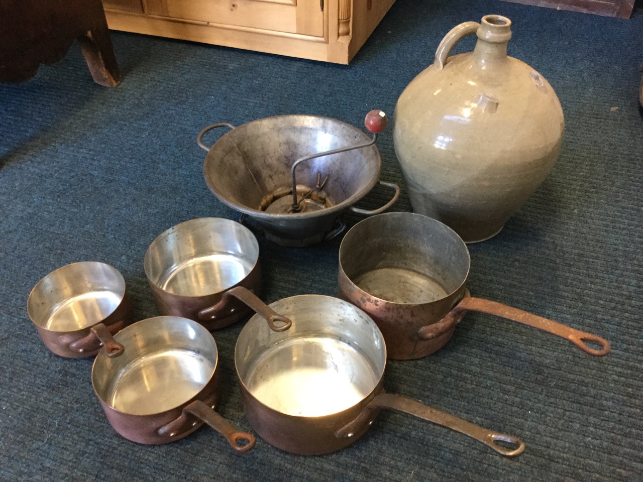 A graduated set of five copper pans riveted with iron handles; a tapering French funnel sieve with