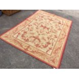 An Aubusson style wool & cotton rug, woven with foliate scrolled field having central floral