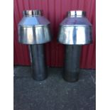 A pair of stainless steel chimney cowels, with tubular supports to shaped covers. (33in) (2)