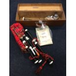 A cased set of bagpipes with leather bellows, oil, spare reids/cork, etc., and four instruction