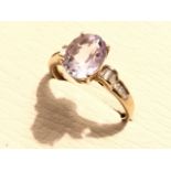 A 9ct gold morganite (pink emerald) & diamond ring, the claw set oval lilac stone flanked by