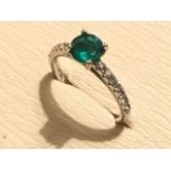 A platinum emerald & diamond shoulder ring, the circular claw set emerald weighing just under a