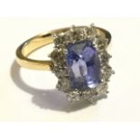 An 18ct yellow gold sapphire & diamond cluster ring, the cushion cut sapphire weighing just over