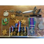 Various medals, mother brooches, a cigarette holder with gold mounts, two bronze ushanti figures,