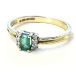 A 9ct gold emerald and diamond ring, the emerald cut central stone framed by borders of three