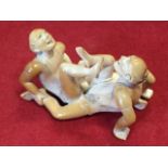 A carved ivory okimono depicting ecstatic couple joined in sodomy, with floral decoration to their