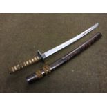A Japanese short sword with wood scabbard and cord bound handle, the pierced tsuba cast with