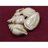 A nineteenth century carved ivory netsuke in the form of a group of shells. (1.5in)