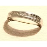 A platinum diamond eternity ring, the ten channel set diamonds set within a tapering hallmarked