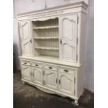 A French farmhouse dresser, the top with moulded cornice above apron having applied leaf carved