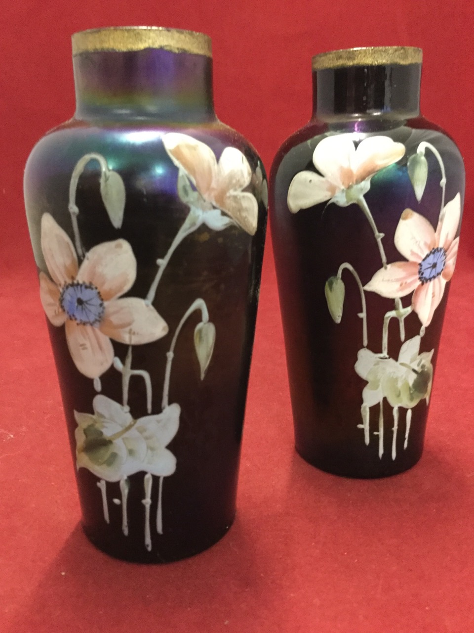 A pair of tapering irridescent lustre glass vases with tubular necks, enamelled in relief with