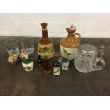 A boozey lot including miniatures, glass tumblers, a Wade bell decanter, a cut glass tankard,