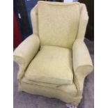 An Edwardian upholstered wing armchair, with loose cushions and covers and long seat with padded