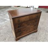 A Georgian style walnut chest of drawers, with moulded top above four long drawers mounted with ring