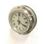 A 60s bulkhead ships clock with sealed electric movement in chromed case, having enamelled dial with