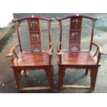 A pair of Chinese armchairs with arched yoke back rails above rectangular splats carved with pierced