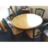 A circular dining table with moulded top on turned column with sabre legs, together with four