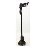 Antique Chinese carved hardwood standard lamp with dragon support on circular base and block feet,