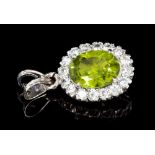 Peridot and diamond cluster pendant with a central oval mixed cut peridot surrounded by sixteen