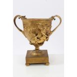 After the antique, gilt metal twin-handled urn modelled in high relief with centaurs and putto,