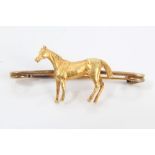 Antique yellow metal bar brooch, mounted with a model of a horse, 4cm wide,