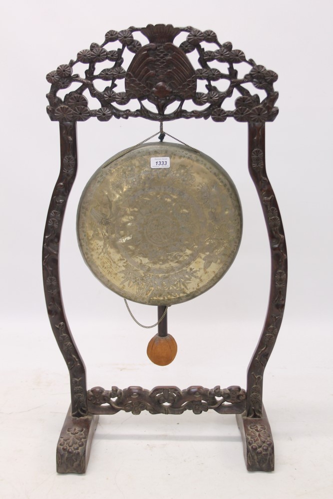 Late 19th / early 20th century Chinese carved hardwood gong stand with tooled metal gong and beater,