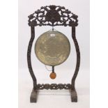 Late 19th / early 20th century Chinese carved hardwood gong stand with tooled metal gong and beater,