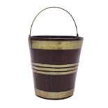 George III mahogany and brass-bound peat bucket of coopered form, with brass swing handle,