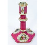 Late 19th century Berlin porcelain candlestick with painted figure reserves on puce and gilt ground,