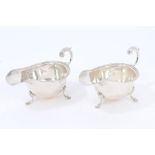 Pair 1930s silver sauce boats of conventional form, with decorative borders and open scroll handle,