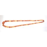 Old amber necklace with a string of graduated oval butterscotch amber beads, approximately 66cm.