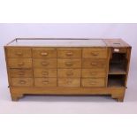 Early 20th century light oak shop display counter with integral till and fitted with drawers and