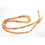 Old amber necklace with a string of graduated oval butterscotch amber beads, approximately 90cm.