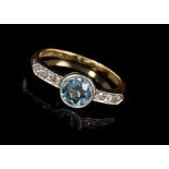 Edwardian aquamarine and diamond ring with a round mixed cut aquamarine flanked by old cut and