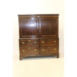 George III oak press cupboard with dentil cornice and interior of slides enclosed by pair of