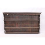 18th century oak plate rack, the projecting cornice hung with hooks,