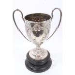 Late Victorian silver two-handled trophy with ornate repoussé foliate scroll decoration and reeded