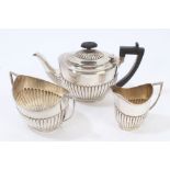 Edwardian silver teapot of half-fluted form, with angular ebony handle,