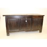 Substantial 17th / 18th century oak coffer, plank lid with iron strap clasp and triple panel front,